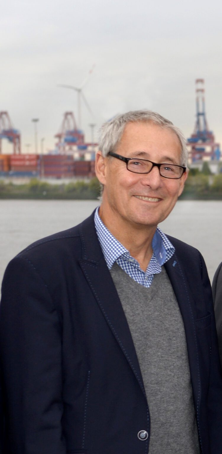Porträt von Wolfgang Przybisch vor den Containerbrücken des Hamburger Hafens, 2015